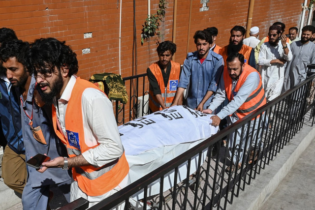Sejumlah orang memindahkan jenazah korban yang tewas akibat runtuhnya atap di sebuah sekolah, dari sebuah rumah sakit di Peshawar pada, Kamis (15/10/2026). Foto: AFP/Abdul Majeed