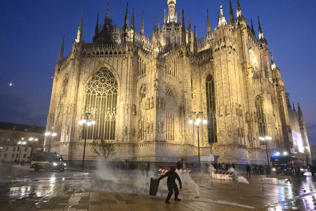 Para pengunjuk rasa terlibat bentrok dengan polisi dalam sebuah aksi protes anti-pemerintah yang diselenggarakan oleh gerakan 'Italia in Piazza' di Piazza Duomo, Milan, Italia, Sabtu (17/10/2026). Foto: Piero CRUCIATTI / AFP