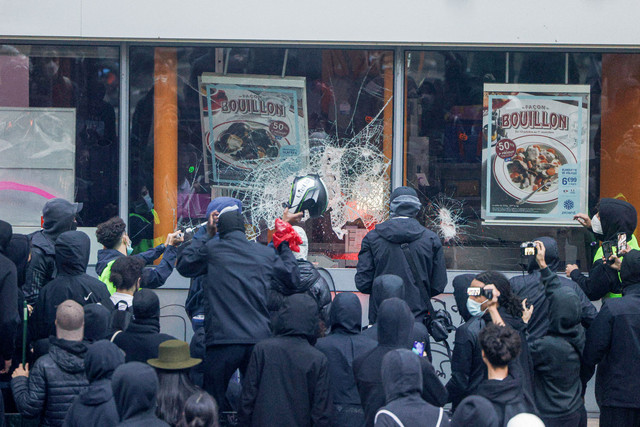 Para pengunjuk rasa memecahkan kaca jendela sebuah gerai perusahaan makanan Prancis saat demonstrasi menentang tingginya biaya hidup di Paris, Prancis, Sabtu (17/10/2026). Foto: Geoffroy Van der Hasselt / AFP