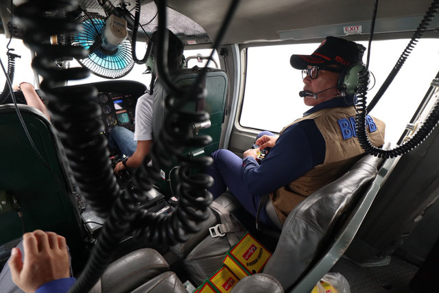 Kepala BNPB Letjen TNI Kristomei Sianturi berkomunikasi dengan pilot saat meninjau karhutla wilayah Sumatra Selatan dari udara menggunakan helikopter BNPB, Minggu (18/10/2026). Foto: Dok. Istimewa