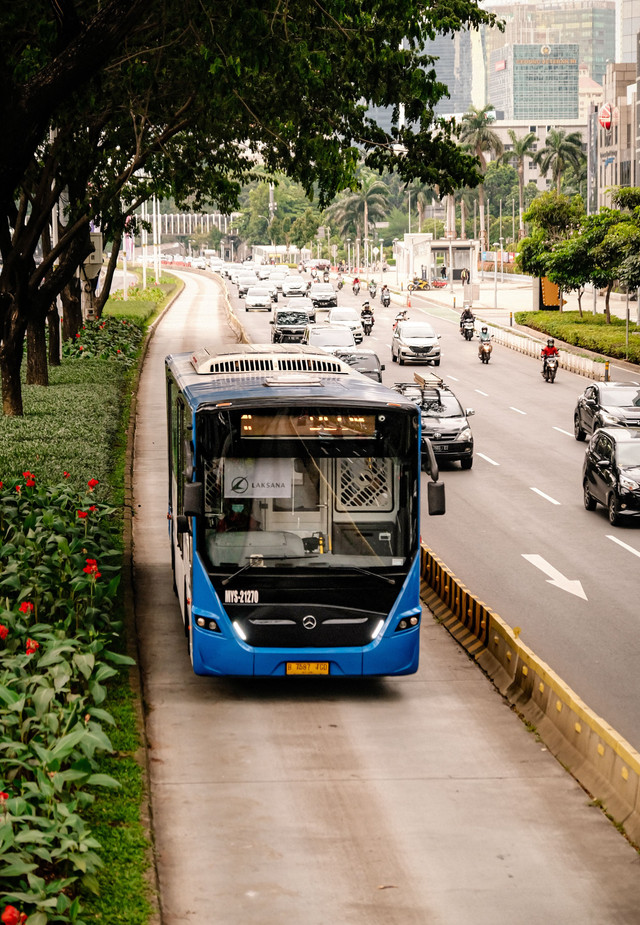 Bus TransJakarta melintas di jalur khusus yang dibatasi separator di tengah lalu lintas perkotaan. Foto: Noval Gani/Pexels.