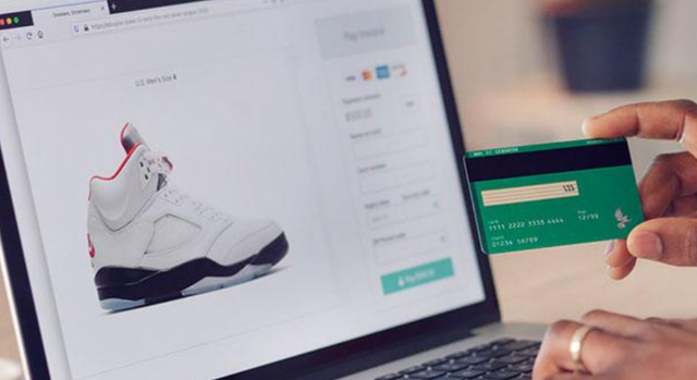 Ilustrasi seseorang memegang kartu debit untuk melakukan transaksi digital, yang menggambarkan kemudahan pembayaran dalam belanja online.https://unsplash.com/photos