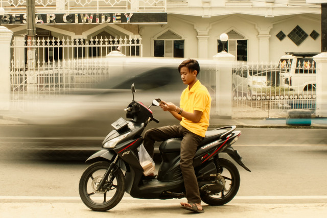 https://www.pexels.com/photo/young-man-on-scooter-reading-by-street-36545508/