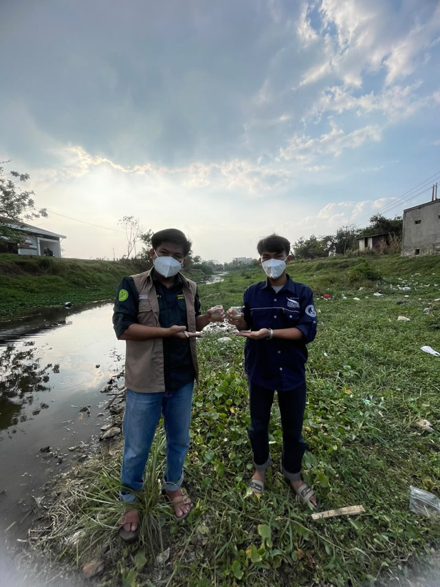 Penulis (Ilman Khoirul Anwar) bersama narasumber Faizal (Karang Taruna Desa Sukamanah) saat mengambil sampel air di Rancaekek untuk diteliti lebih lanjut. (Foto: Dok. Pribadi)