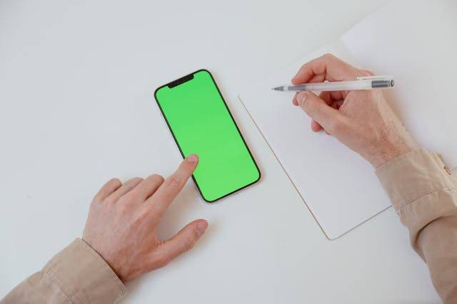 Ilustrasi garis hijau di layar HP. Foto: Unsplash