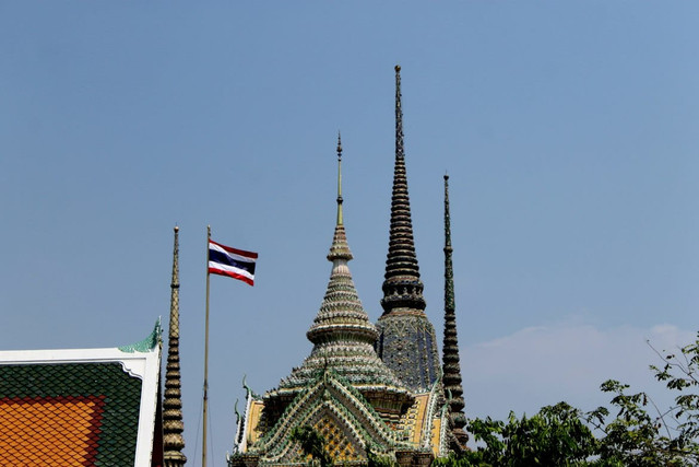 Thai temple tower with flag flying high. Foto: unsplash.com