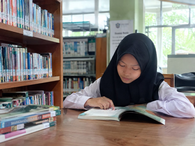 (Ilustrasi : Anak sekolah membaca buku di perpustakaan)