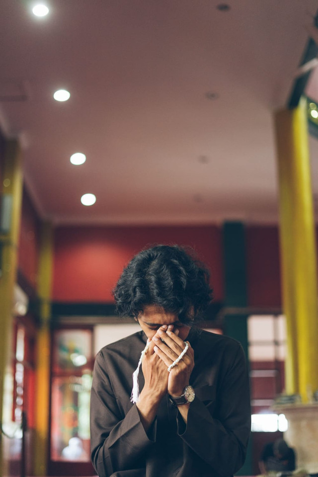 Ilustrasi : Seseorang yang sedang khusyuk berdoa kepada tuhan. Photo : Rizky Sabriansyah/pexels