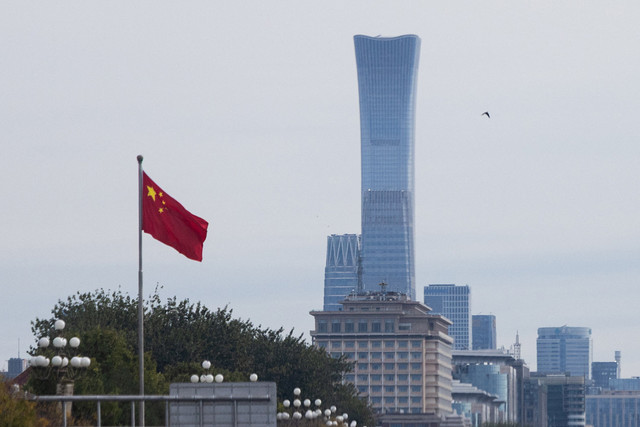 Bendera nasional China berkibar di depan gedung-gedung pencakar langit di Distrik Pusat Bisnis (CBD) saat para pemimpin Partai Komunis China membuka sesi pleno kelima Komite Sentral ke-20 secara tertutup, di Beijing, China, Senin (26/10/2026). Foto: Maxim Shemetov/REUTERS