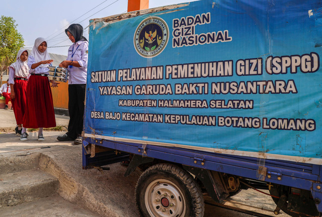 Petugas SPPG memberikan paket MBG kepada siswa SD Negeri 9 Halmahera Selatan saat distribusi MBG di Desa Bajo Kecamatan Botang Lomang, Kabupaten Halmahera Selatan, Maluku Utara, Senin (26/10/2026). Foto: Andri Saputra/ANTARA FOTO
