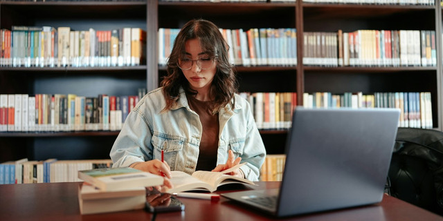 Mahasiswa sedang belajar menggunakan laptop dan buku sebagai gambaran perjuangan meraih prestasi akademik selama kuliah. (Sumber Google: Pexels – Student Studying)