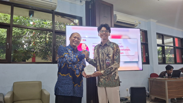 Dr. Prianto Budi Saptono, Ak., CA, MBA menyerahkan pelakat kepada perwakilan peserta. Sumber: Dokumentasi Pribadi.