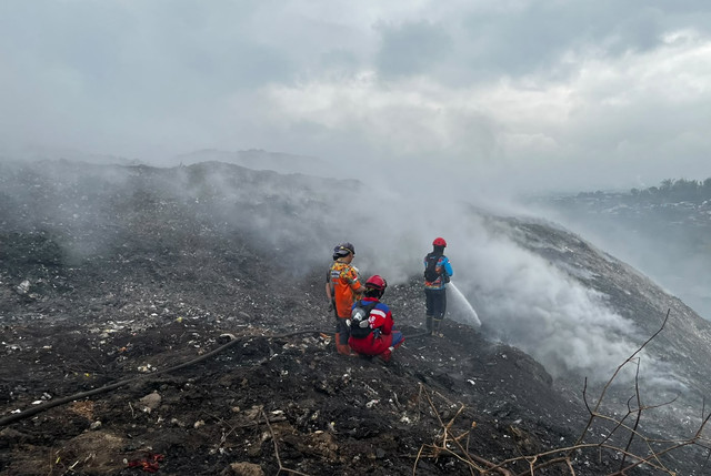 Petugs memadamkan kebakaran berusaha memadamkan api yang membakar tumpukkan sampah di Tempat Pembuangan Akhir (TPA) Supiturang, Kota Malang, Selasa (27/10/2026). Foto: Dok. Istimewa