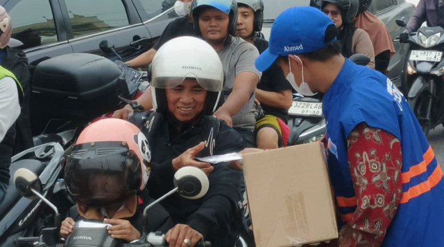 Relawan DT Peduli Membagikan Masker dan Multivitamin untuk Masyarakat di Kawasan Lampu Merah Angkatan 66, Sekip Ujung, Kota Palembang (Sumber: DT Peduli)