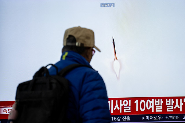 Seorang pria berjalan melewati layar yang menampilkan liputan berita berisi rekaman arsip peluncuran rudal Korea Utara di Stasiun Seoul, Korea Selatan, Kamis (29/10/2026). Foto: Philip Fong / AFP