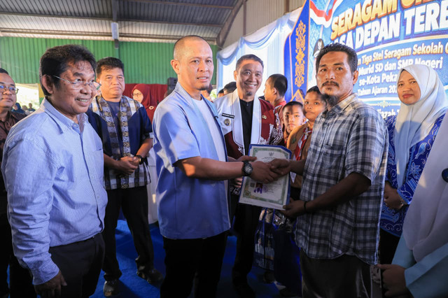 Wali Kota Pekanbaru Agung Nugroho serahkan secara simbolis seragam gratis bagi 19.900 siswa SD dan SMP negeri se-Kota Pekanbaru di Aula SMPN 6 Pekanbaru, Kamis (29/10/2026). Foto: Dok. Diskominfo Pekanbaru