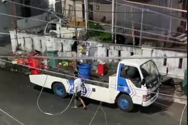 Dua pria buang sampah yang diangkut mobil towin polisi di Ternate, Kamis (29/10/2026). Foto: Dok. Istimewa