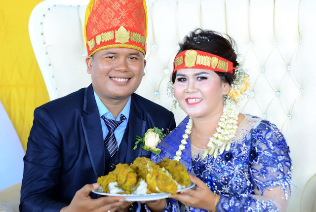 Foto pasangan pengantin dalam balutan busana adat Batak.Sumber Foto: Dokumentasi pribadi penulis