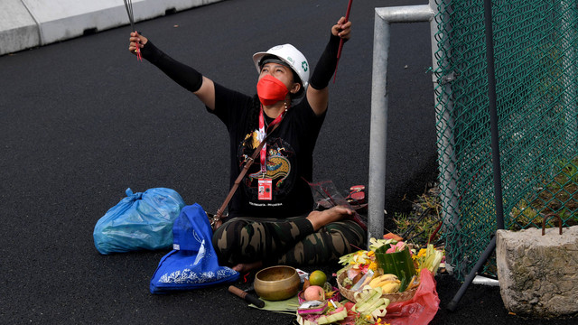 Pawang hujan saat melakukan ritual tradisionalsaat sesi latihan untuk MotoGP di Sirkuit Internasional Mandalika di Kuta Mandalika di Lombok Tengah, Jumat (18/3/2022). Foto: Sony Tumbelaka/AFP