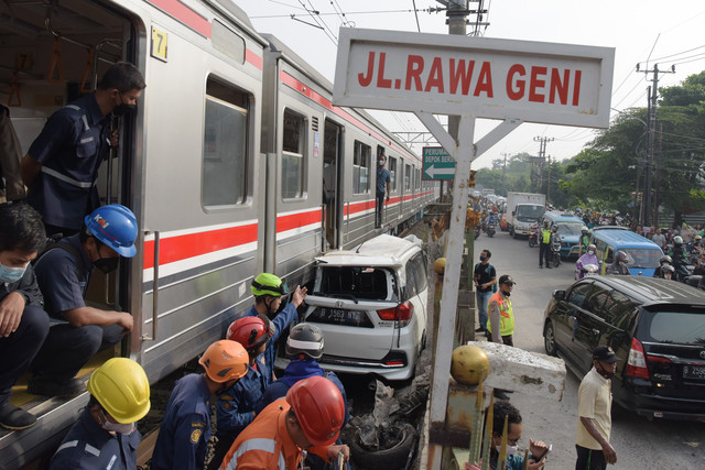 Sejumlah petugas berusaha mengevakuasi mobil Honda Mobilio yang tertabrak KRL Commuterline KA 1077 (Bogor-Jakarta Kota) di kawasan Rawageni, Ratu Jaya, Cipayung, Depok, Jabar, Rabu (20/4/2022). Foto: Andika Wahyu/ANTARA FOTO