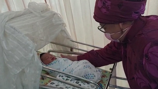 TOKOH masyarakat Riau, Hj Azlaini Agus, saat membelai anak laki-laki Ustaz Abdul Somad (UAS) yang baru lahir, Jumat (18/2/2022), di RSIA Eria Bunda. UAS beri nama anaknya Samy  