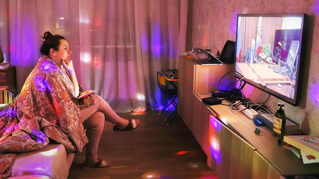 Seorang perempuan di St Petersburg tengah menonton Presiden Putin di televisi pekan lalu