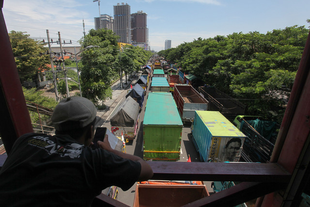 Sejumlah truk berbagai jenis terparkir saat pengemudinya berunjuk rasa terkait aturan Over Dimension and Over Loading (ODOL) di frontage Jalan A Yani, Surabaya, Jawa Timur, Selasa (22/2/2022). Foto: Didik Suhartono/ANTARA FOTO
