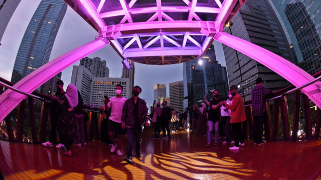 Sejumlah warga menikmati suasana di Jembatan Penyeberangan Orang (JPO) Pinisi di Jalan Jenderal Sudirman, Jakarta, Sabtu (12/3/2022). Foto: Aditya Pradana Putra/ANTARA FOTO