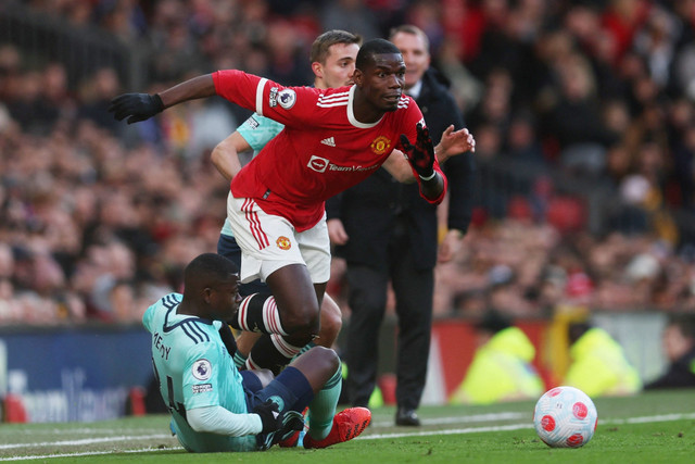 Pemain Manchester United Paul Pogba beraksi dengan pemain Leicester City Nampalys Mendy dan Timothy Castagne di Stadion Old Trafford, Manchester, Inggris, Sabtu (2/4/2022). Foto: Russell Cheyne/REUTERS