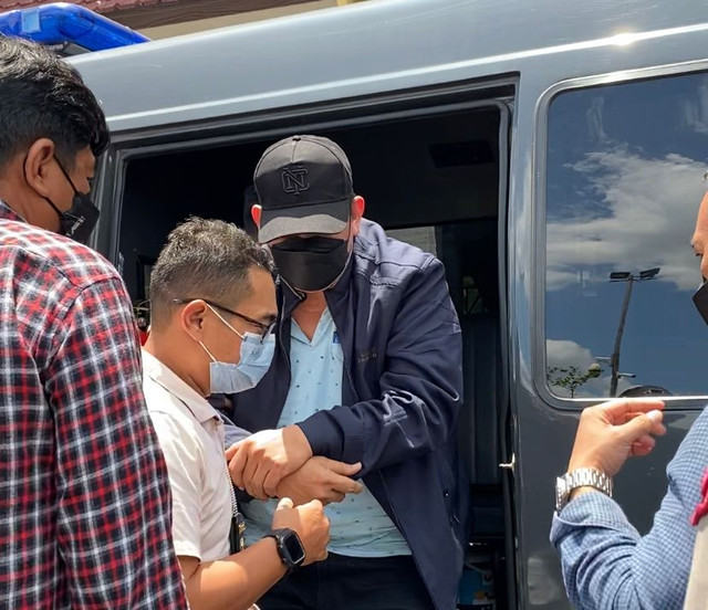 Ketua Kadin Kalbar, Joni Isnaini (bertopi), saat digiring personel Direktorat Reskrimsus Polda Kalbar. Foto: Teri/Hi!Pontianak