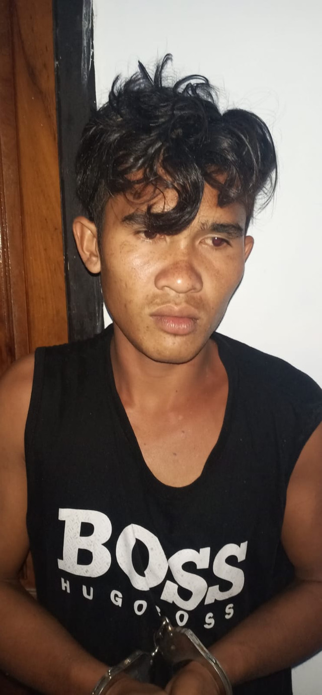 La Labi (20) dengan tangan terborgol usai diamankan pihak kepolisian Polres Muna karena menikam Kapolsek Towea. Foto: Al Pagala/kendarinesia.
