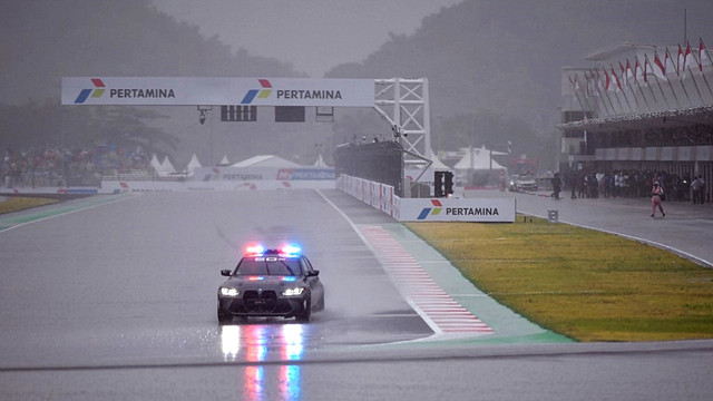 Safety Car melintas saat hujan deras sebelum dimulainya balapan MotoGP di Sirkuit Mandalika, Lombok, Nusa Tenggara Barat pada Minggu (20/3/2022)
 Foto: Bay Ismoyo/AFP