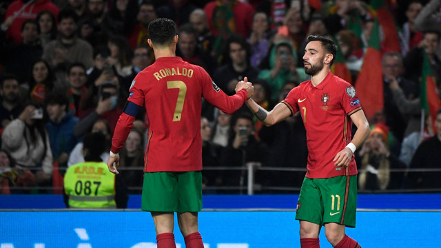 Pemain Portugal Bruno Fernandes dan Cristiano Ronaldo melakukan selebrasi saat melawan Makedonia Utara pada pertandingan sepak bola leg pertama final kualifikasi Piala Dunia 2022 di stadion Dragao di Porto. Foto: Miguel Riopa/AFP