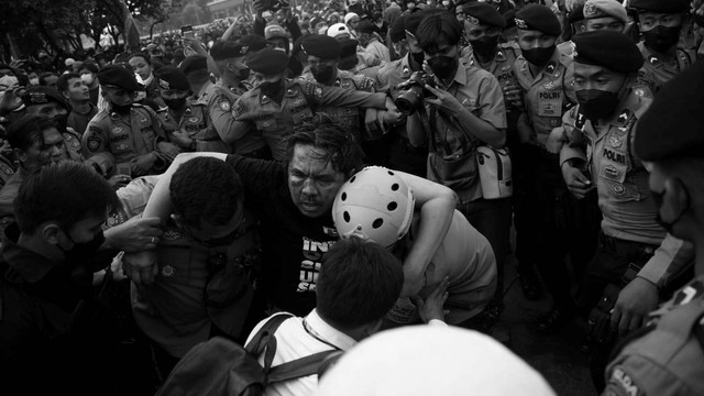 Polisi membawa Ade Armando yang terluka saat demo 11 April di Gedung DPR RI, Jakarta, Senin (11/4). Foto: Aditia Noviansyah/kumparan
