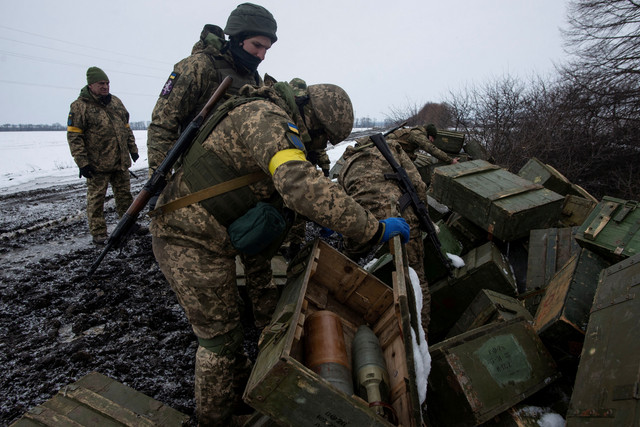 Prajurit Ukraina memeriksa amunisi dari kendaraan militer yang hancur, di tengah invasi Rusia ke Ukraina, di wilayah Sumy, Ukraina, Senin (7/3/2022). Foto: Ukrainian Ground Forces/Handout via REUTERS