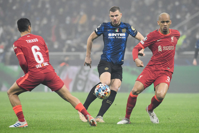 Pemain Inter Milan Edin Dzeko berusaha melewati pemain Liverpool pada pertandingan 16 besar Liga Champions di San Siro, Milan, Italia. Foto: Filippo MONTEFORTE / AFP