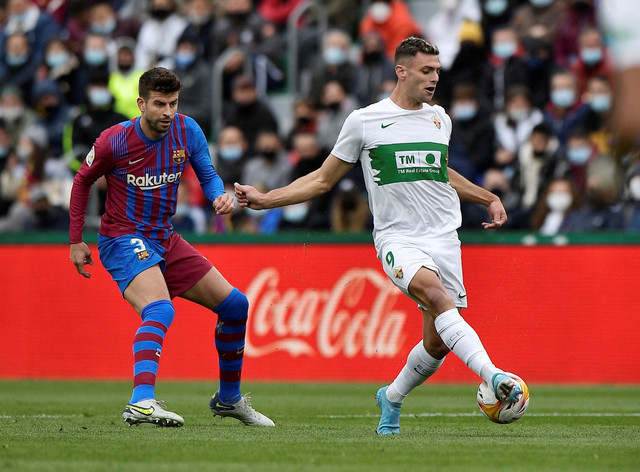 Pemain Elche Lucas Boye duel dengan pemain FC Barcelona Gerard Pique pada pertandingan Liga Spanyol di Estadio Manuel Martinez Valero, Elche, Spanyol. Foto: Pablo Morano/Reuters