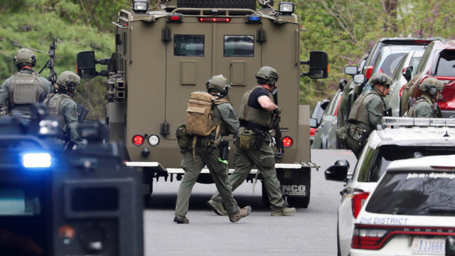 Petugas tim taktis penegak hukum bergerak ke area penembakan yang dilaporkan dan penembak aktif di dekat Sekolah Menengah Edmund Burke di lingkungan Taman Cleveland di Northwest Washington, AS, Jumat (23/4/2022). Foto: Evelyn Hockstein/REUTERS