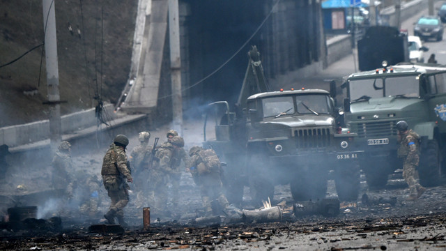 Para Militer di Ukraina membersihkan puing sisa pertempuran dengan Rusia di Kiev pada (26/2). Foto: Sergei SUPINSKY / AFP