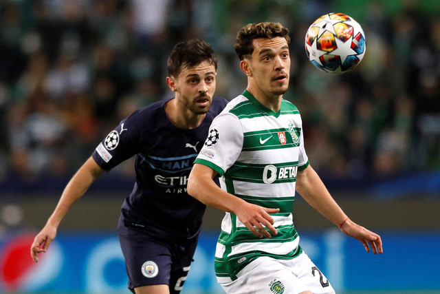 Pemain Manchester City Bernardo Silva berebut bola dengan pemain Sporting CP Pedro Goncalves pada pertandingan 16 besar Liga Champions di Estadio Jose Alvalade, Lisbon, Portugal, Rabu (16/2/2022). Foto: Pedro Nunes/REUTERS