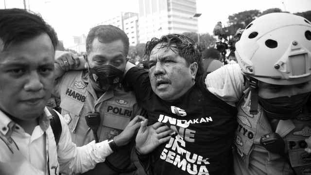 Polisi membawa Ade Armando yang terluka saat demo 11 April di Gedung DPR RI, Jakarta, Senin (11/4). Foto: Aditia Noviansyah/kumparan
