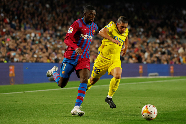 Pemain FC Barcelona Ousmane Dembele berusaha melewati pemain Cadiz pada pertandingan lanjutan Liga Spanyol di Camp Nou, Barcelona, Spanyol. Foto: Albert Gea/REUTERS