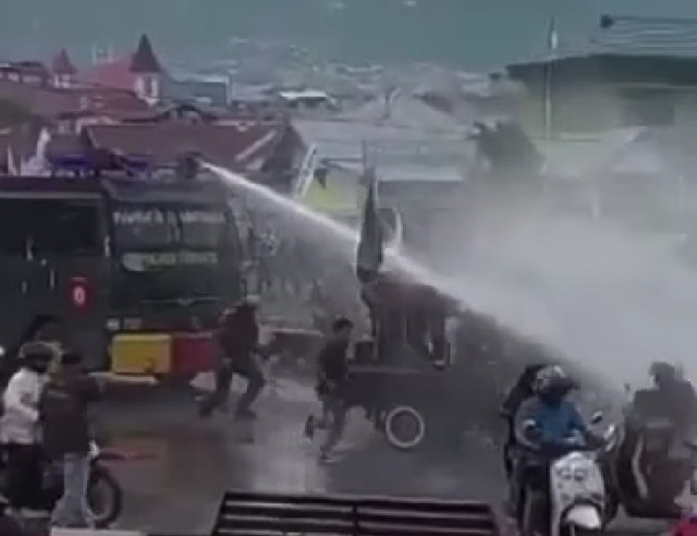 Mobil water cannon menyemprotkan air ke arah mobil pick up, yang mengangkut sound system milik warga yang disewa mahasiswa, saat aksi penolakan kenaikan harga BBM jilid II di Kota Ternate, Maluku Utara. Foto: tangkapan layar video viral. 