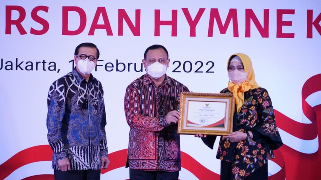Firli Bahuri memberikan penghargaan kepada istrinya Ardina Safitri di acara peluncuran hymne dan mars KPK, Kamis (17/2/2022). Foto: Twitter/@BSiumlala
