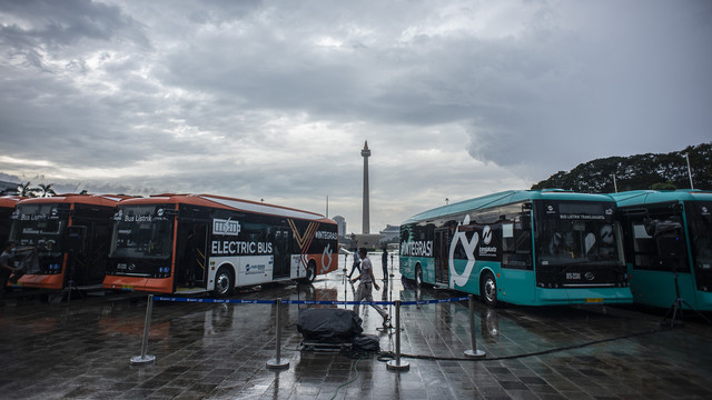 Petugas berjalan di dekat Bus Listrik Transjakarta di Plaza Monas, Jakarta, Selasa (8/3/2022). Foto: Aprillio Akbar/ANTARA FOTO