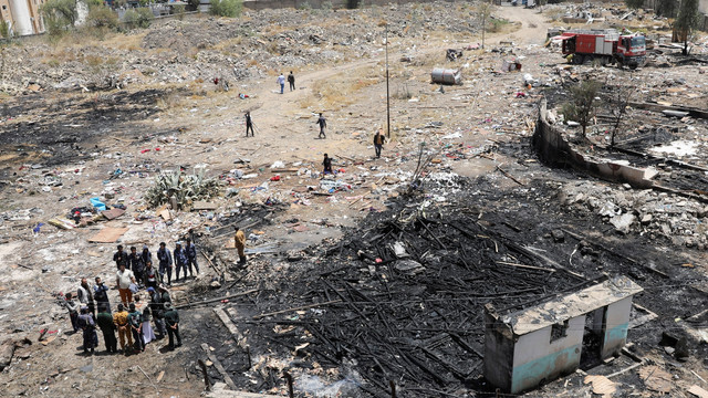 Orang-orang berdiri di lokasi serangan udara pimpinan Saudi di Sanaa, Yaman, Sabtu (26/3/2022). Foto: Khaled Abdullah/REUTERS