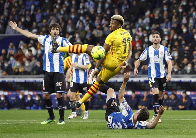 Pemain FC Barcelona Adama Traore berebut bola dengan pemain Espanyol pada pertandingan lanjutan Liga Spanyol di RCDE Stadium, Barcelona, Spanyol. Foto: Albert Gea/REUTERS