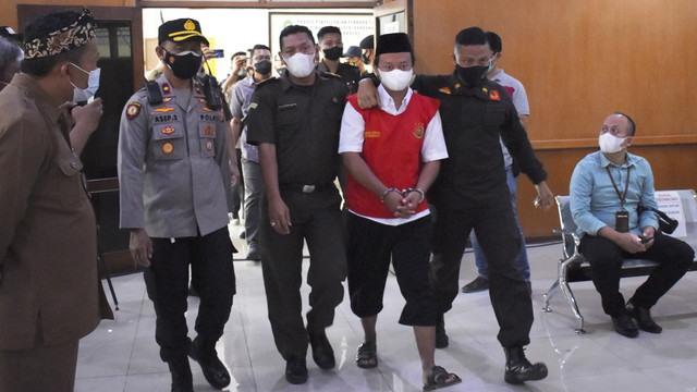Terpidana kasus kekerasan seksual terhadap anak Herry Wirawan (kedua kanan) berjalan memasuki ruangan untuk menjalani sidang vonis di Pengadilan Negeri Bandung, Jawa Barat, Selasa (15/2/2022). Foto: Rafi Fadh/AP Photo