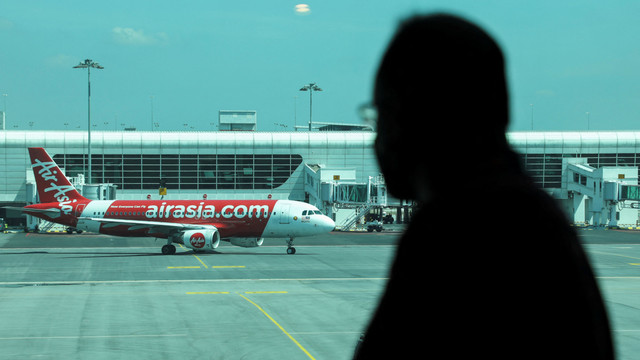 Seorang pria melihat pesawat Air Asia di Bandara Internasional Kuala Lumpur 2 (KLIA2), Sepang, Selangor, Malaysia, (1/4/2022). Foto: Hasnoor Hussain/REUTERS