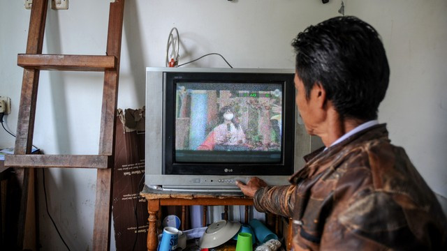 Seorang petugas keamanan menonton siaran TV analog di Cinunuk, Kabupaten Bandung, Jawa Barat, Kamis (17/2/2022). Foto: Raisan Al Farisi/ANTARA FOTO